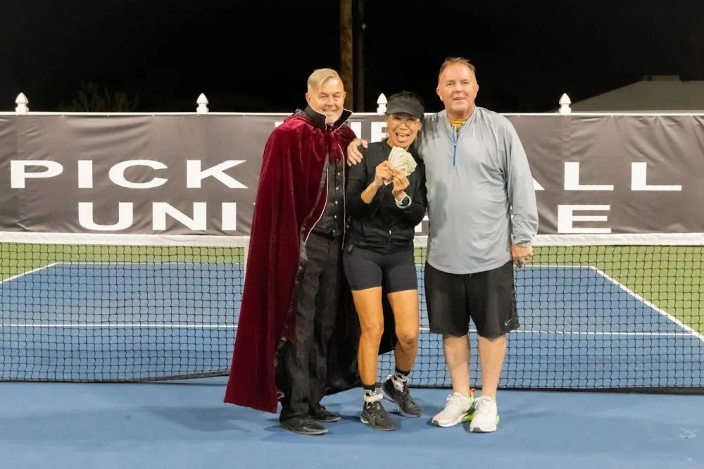 Players on court at night holding cash winnings from Moneyball night